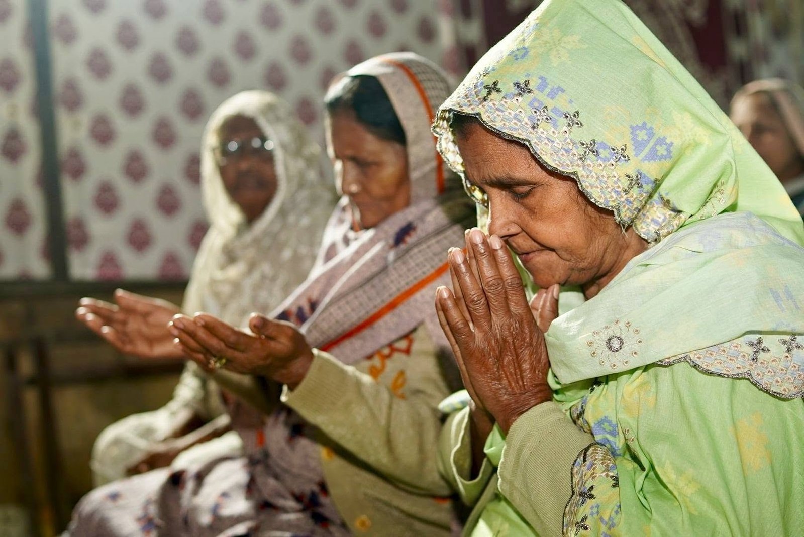 Women in prayer during a gospel gathering